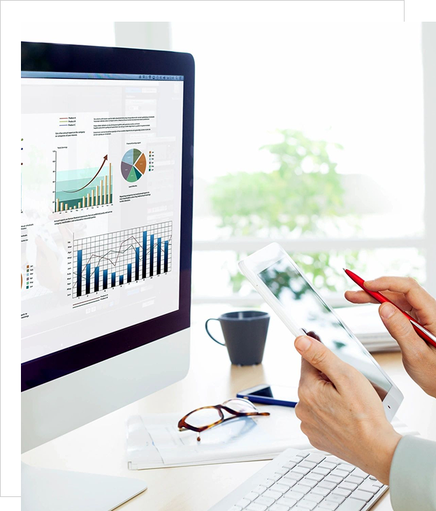 Person analyzing financial data on a computer and tablet.